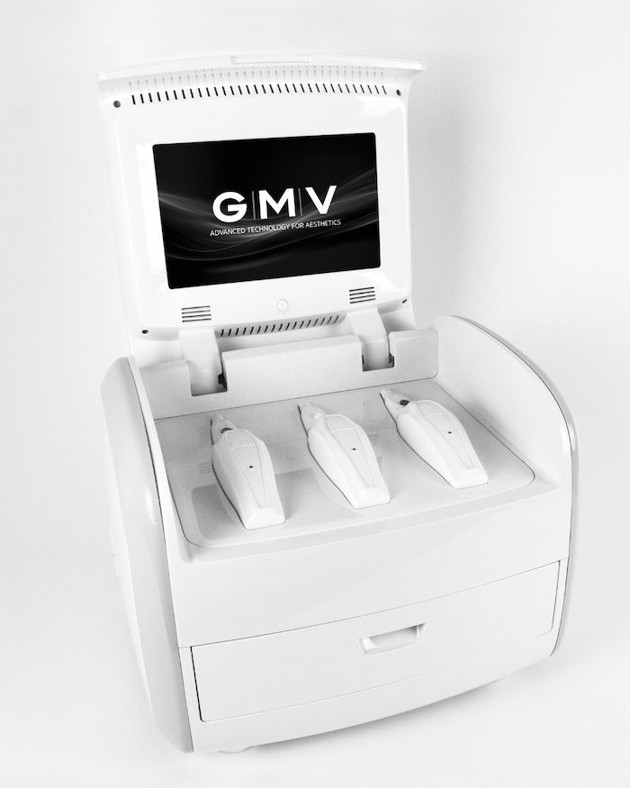 White GMV aesthetic device with touchscreen displaying logo and three handheld applicators docked in base